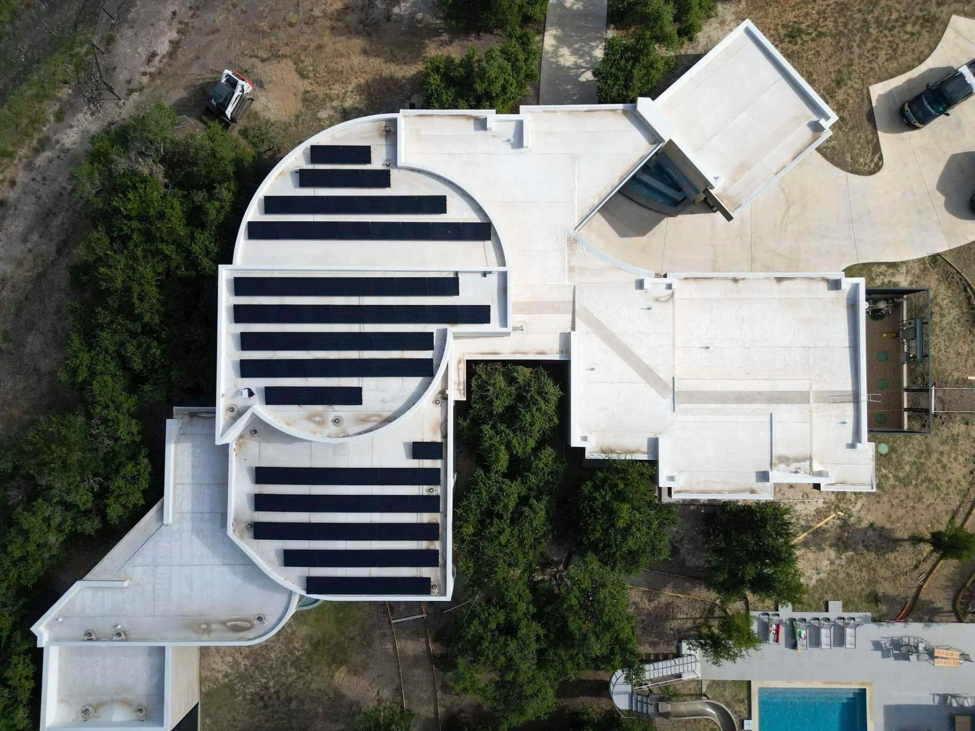 Overhead view of solar panel rows on a curved flat roof in Texas by Good Faith Energy