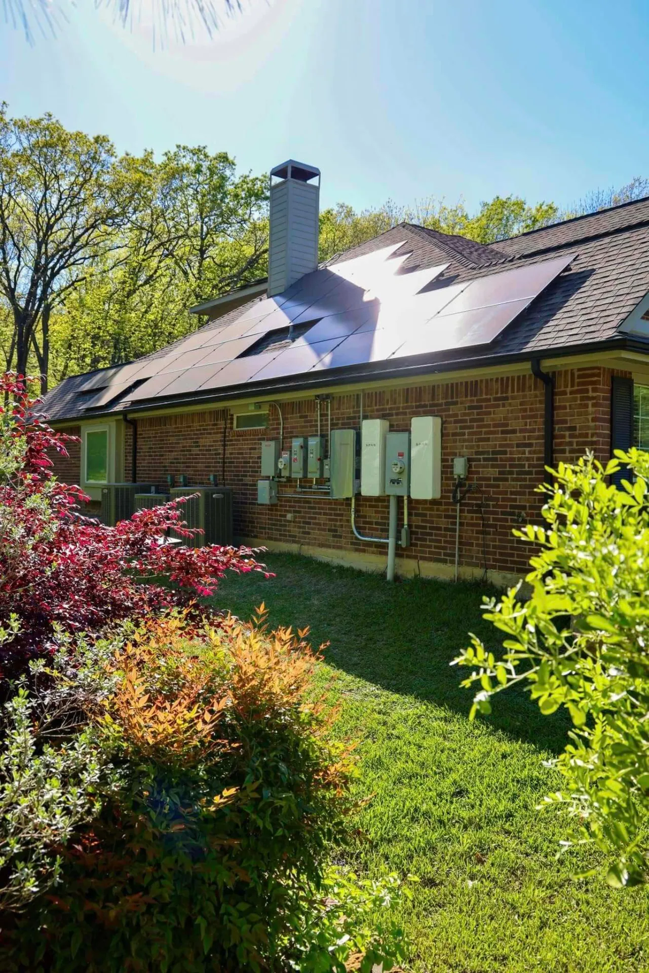 Texas brick home with rooftop solar panels and SPAN smart panels installed by Good Faith Energy