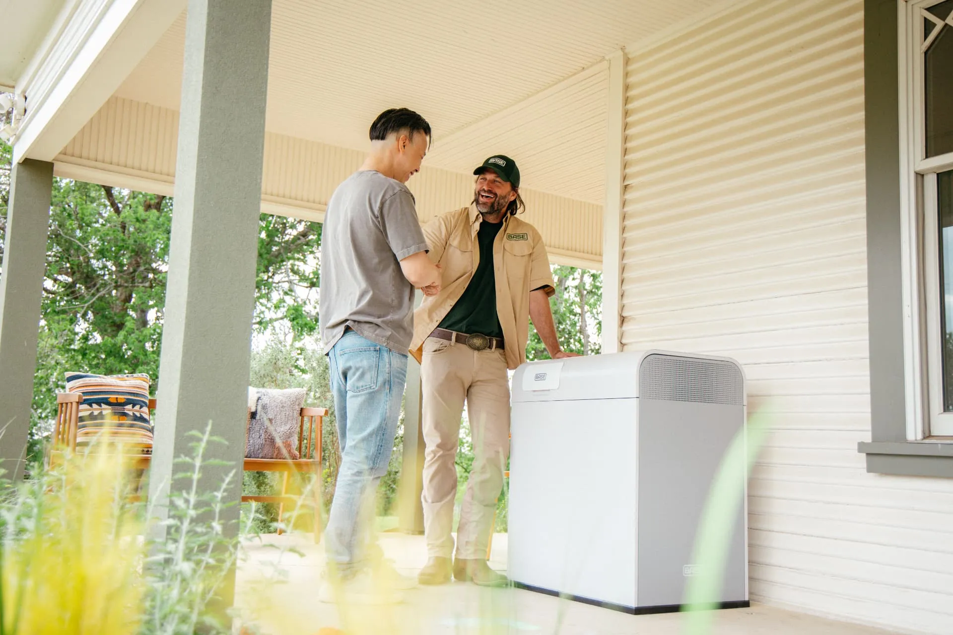 Base technician shaking hands with a homeowner after installing a Base Power battery