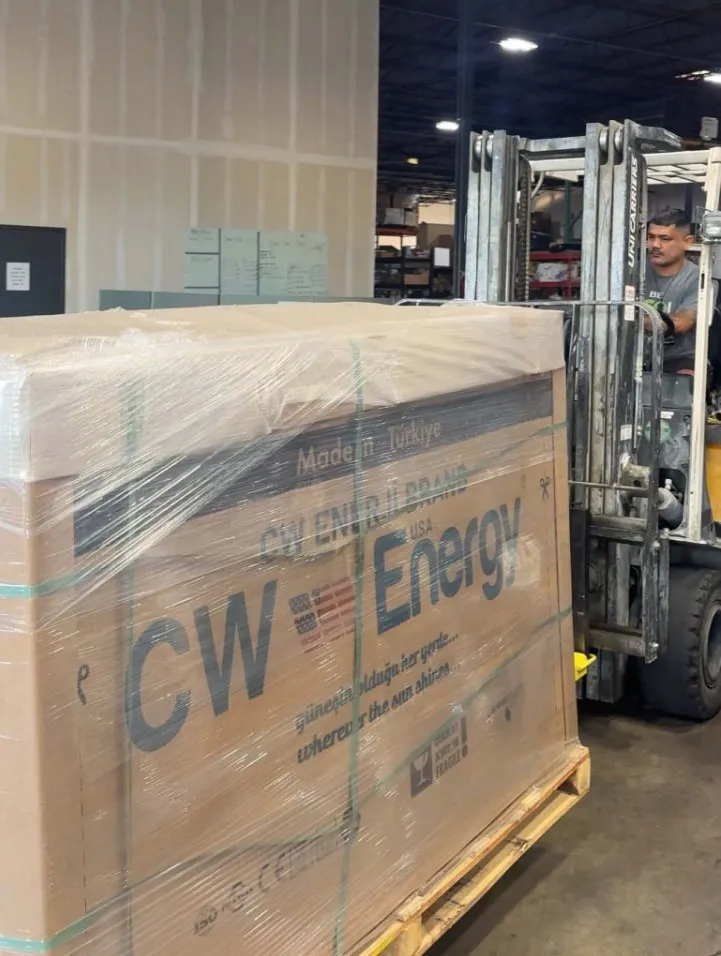 A pallet of factory-sealed CW Enerji solar panels being unloaded at a Good Faith Energy warehouse