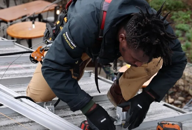 Footprint Project volunteer installing mobile solar racking on a rooftop