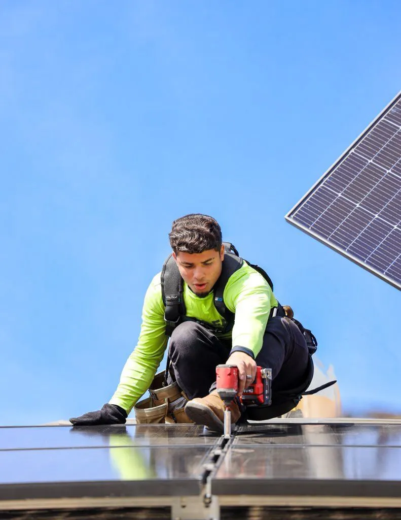 Good Faith Roofing technician installing solar panels on a Texas rooftop