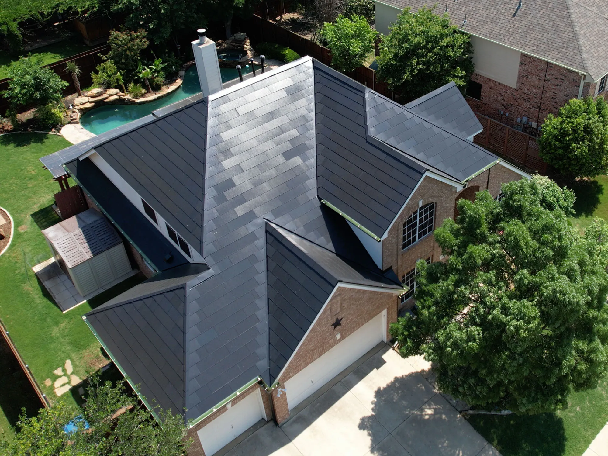 Tesla Solar Roof on a traditional brick home with pool