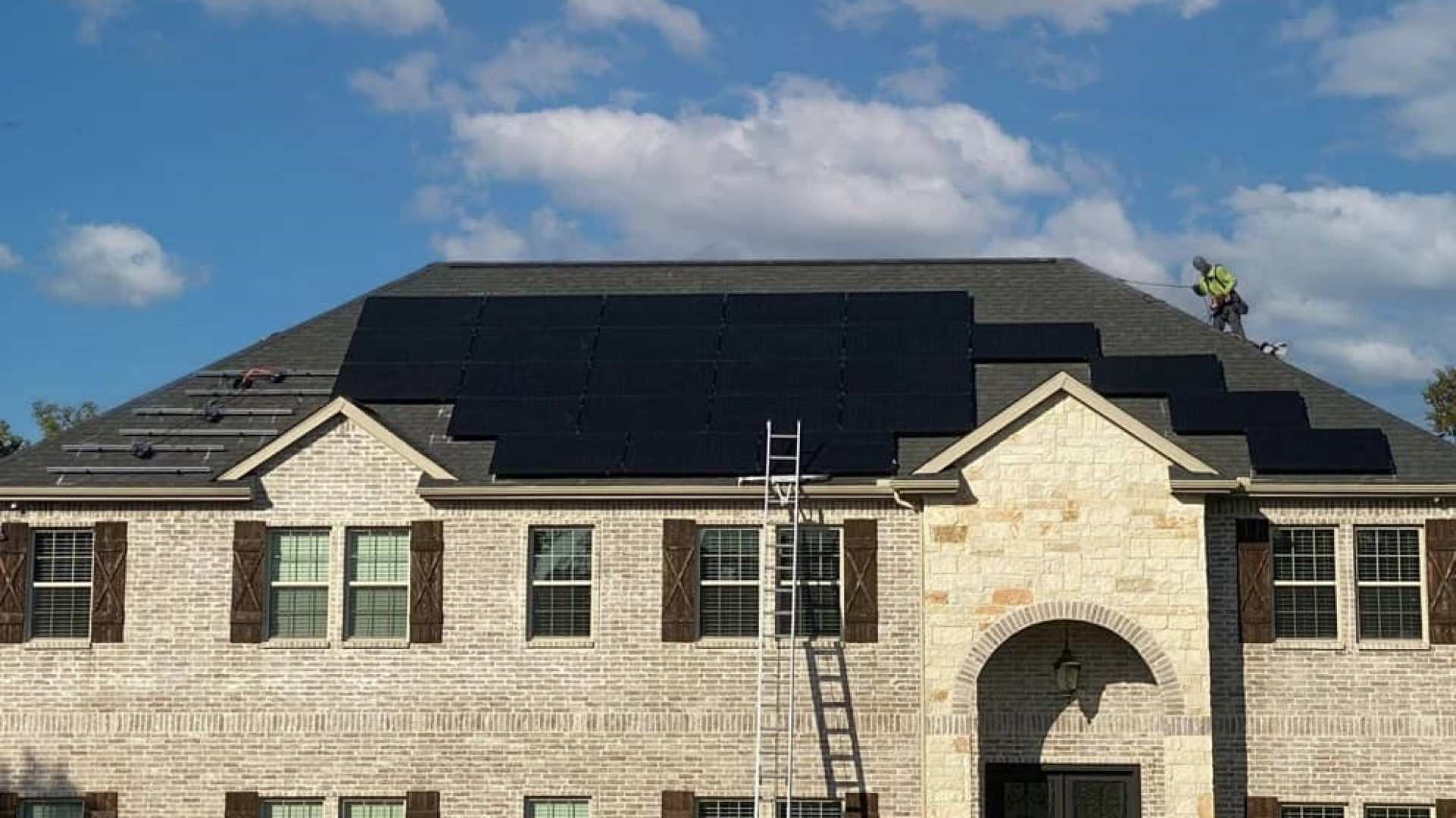 Roofer installing solar panels, official Good Faith Energy photo
